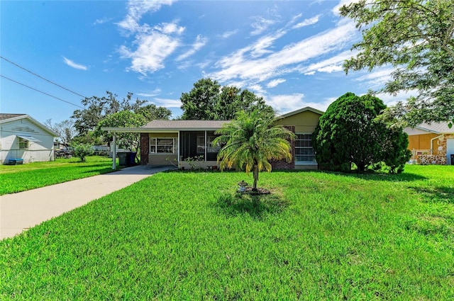 444 Flamingo Dr, Apollo Beach, FL 33572 - view of front facade with concrete driveway, a front yard, a carport, and a sunroom