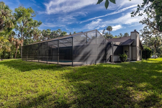 3804 65th St E, Bradenton, FL 34208 - back of property with a lawn, a chimney, a lanai, and an outdoor pool