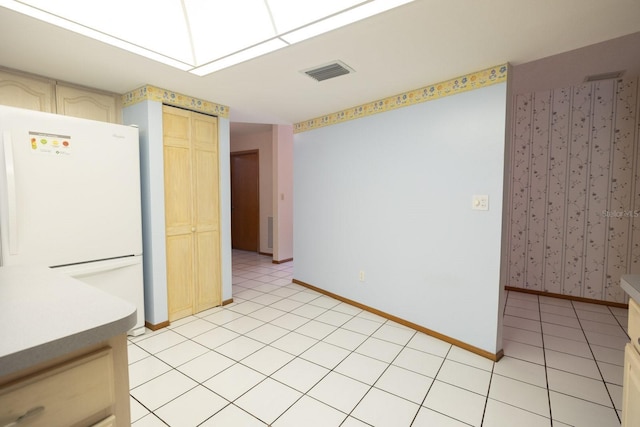 3804 65th St E, Bradenton, FL 34208 - kitchen featuring freestanding refrigerator, light tile patterned floors, and cream cabinetry