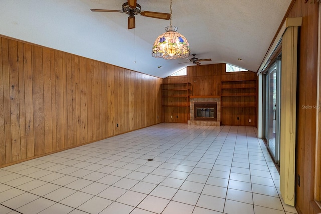 3804 65th St E, Bradenton, FL 34208 - unfurnished living room featuring ceiling fan, vaulted ceiling, wood walls, and a fireplace