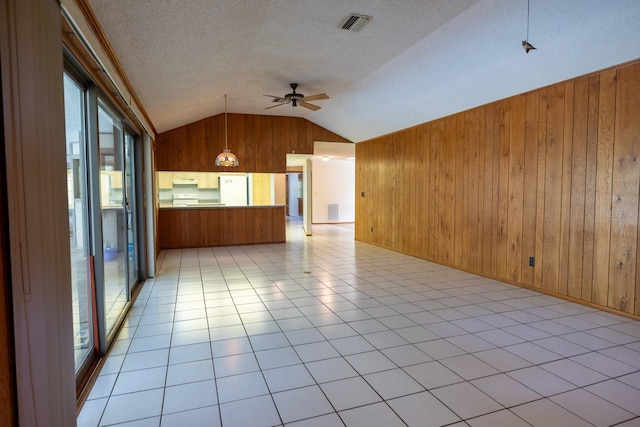3804 65th St E, Bradenton, FL 34208 - unfurnished living room with a ceiling fan, vaulted ceiling, wood walls, and a textured ceiling