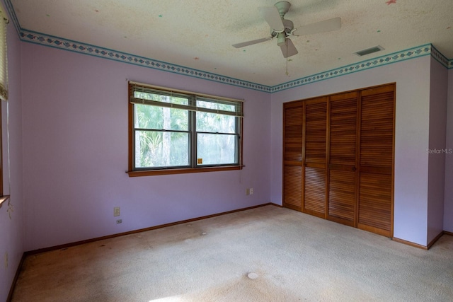 3804 65th St E, Bradenton, FL 34208 - unfurnished bedroom with carpet, a closet, a textured ceiling, and a ceiling fan