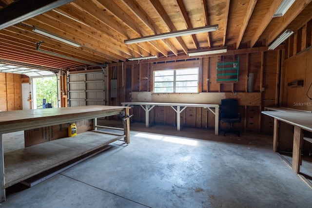 3804 65th St E, Bradenton, FL 34208 - miscellaneous room featuring unfinished concrete flooring, electric panel, a workshop area, and a garage