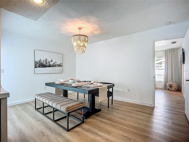 912 Ponderosa Pine Ln, Sarasota, FL 34243 - dining room with a chandelier, a textured ceiling, and light wood-style floors