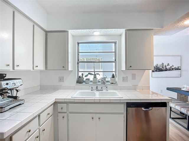 912 Ponderosa Pine Ln, Sarasota, FL 34243 - kitchen with stainless steel dishwasher, tile countertops, and white cabinets