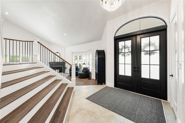 1484 Seafarer Dr, Osprey, FL 34229 - foyer entrance featuring vaulted ceiling, french doors, light tile patterned flooring, stairs, and a chandelier
