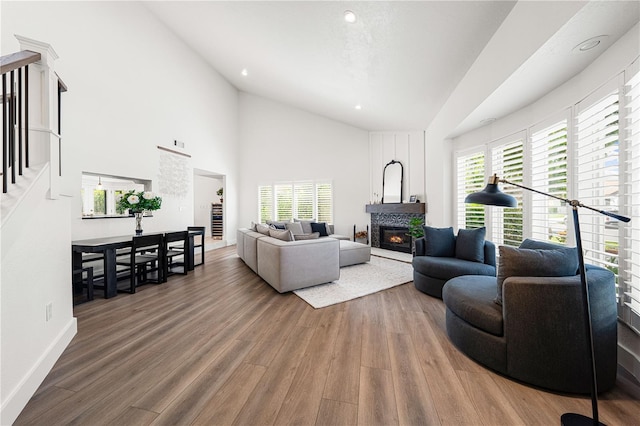 1484 Seafarer Dr, Osprey, FL 34229 - living room featuring a glass covered fireplace, wood finished floors, high vaulted ceiling, and recessed lighting