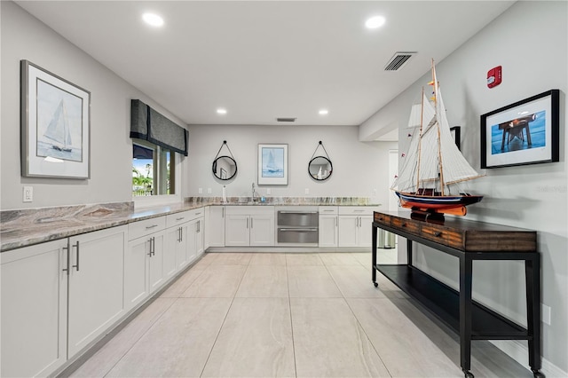 1484 Seafarer Dr, Osprey, FL 34229 - kitchen with recessed lighting, white cabinets, light stone countertops, and light tile patterned floors