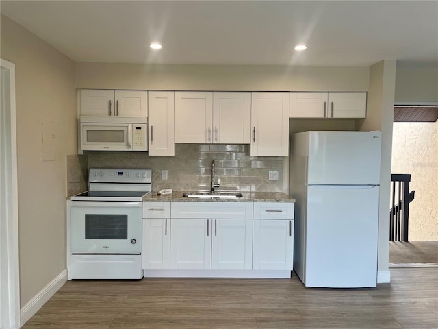 2636 Hidden Lake Dr N Unit G, Sarasota, FL 34237 - kitchen with white appliances, white cabinets, decorative backsplash, light stone counters, and recessed lighting