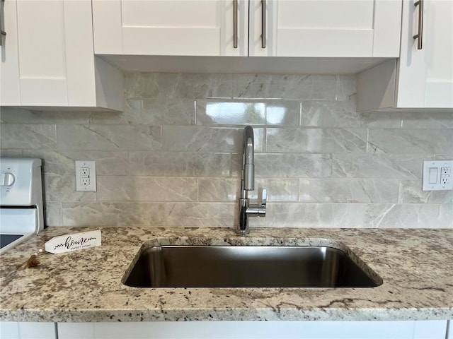 2636 Hidden Lake Dr N Unit G, Sarasota, FL 34237 - kitchen view of white cabinets, decorative backsplash, and light stone countertops
