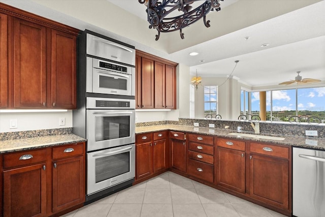 5100 Jessie Harbor Dr Unit 701, Osprey, FL 34229 - kitchen with stainless steel appliances, a chandelier, stone countertops, and light tile patterned flooring
