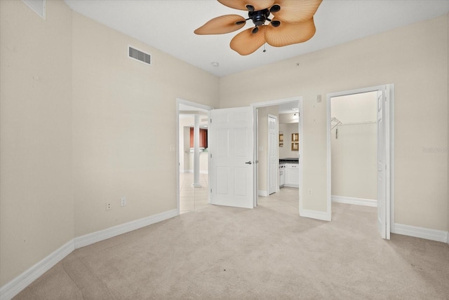 5100 Jessie Harbor Dr Unit 701, Osprey, FL 34229 - unfurnished bedroom featuring light carpet, ensuite bath, a walk in closet, and ceiling fan