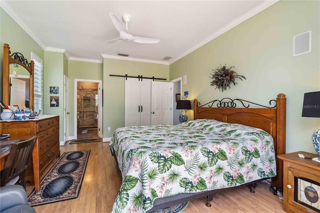 315 36th St NE, Bradenton, FL 34208 - bedroom featuring wood finished floors, crown molding, a barn door, a closet, and a ceiling fan
