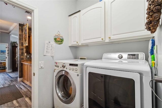 315 36th St NE, Bradenton, FL 34208 - laundry room with washing machine and clothes dryer, wood finished floors, cabinet space, and ornamental molding