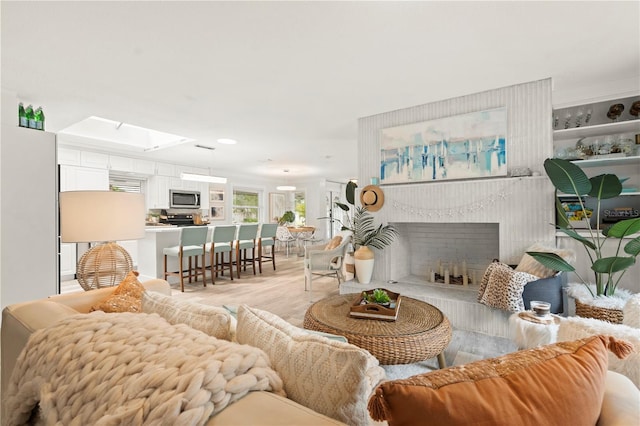 1112 Montezuma Dr, Bradenton, FL 34209 - living area with a fireplace, light wood-style flooring, a skylight, and recessed lighting