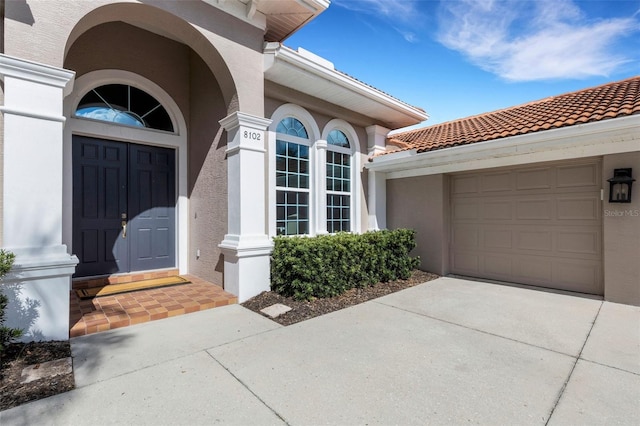 8102 Waterview Blvd, Lakewood Ranch, FL 34202 - property entrance with stucco siding, an attached garage, driveway, and a tile roof