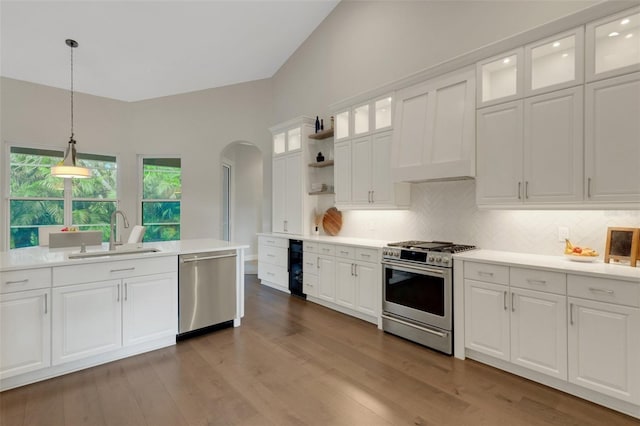 8102 Waterview Blvd, Lakewood Ranch, FL 34202 - kitchen with appliances with stainless steel finishes, arched walkways, hanging light fixtures, open shelves, and light countertops