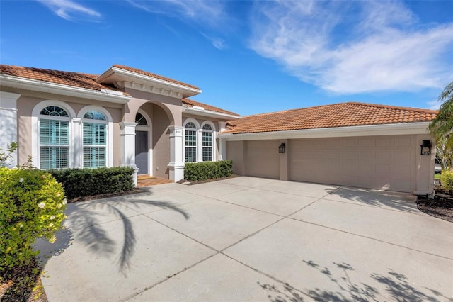 8102 Waterview Blvd, Lakewood Ranch, FL 34202 - mediterranean / spanish home featuring a tiled roof, stucco siding, an attached garage, and driveway