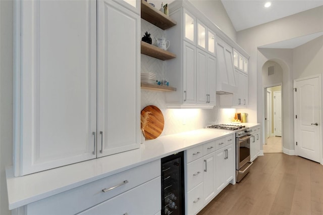 8102 Waterview Blvd, Lakewood Ranch, FL 34202 - kitchen with high end stainless steel range oven, wine cooler, open shelves, decorative backsplash, and white cabinets