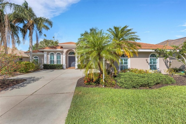 8102 Waterview Blvd, Lakewood Ranch, FL 34202 - mediterranean / spanish-style home with concrete driveway, stucco siding, a front lawn, and a tile roof