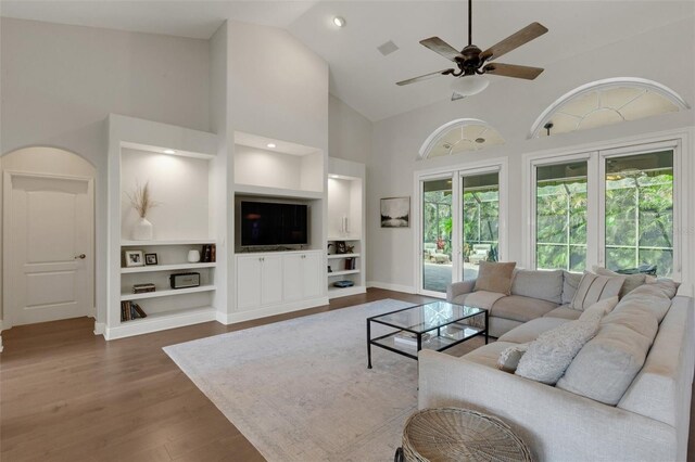 8102 Waterview Blvd, Lakewood Ranch, FL 34202 - living room featuring high vaulted ceiling, built in shelves, wood finished floors, and a ceiling fan