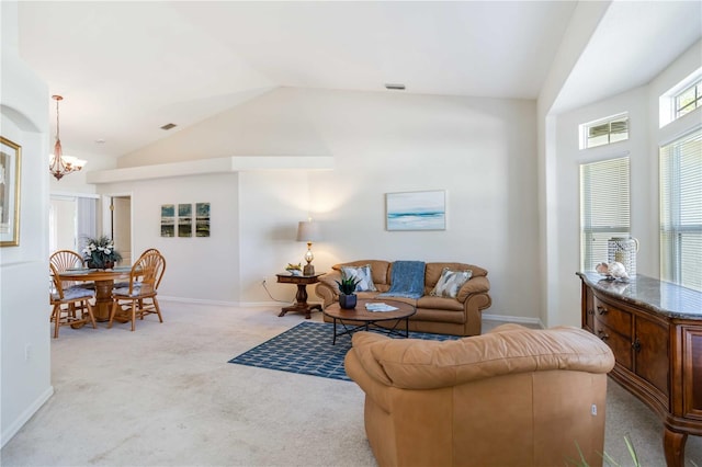 4845 Post Pointe Dr, Sarasota, FL 34233 - living room with lofted ceiling, a chandelier, and carpet floors