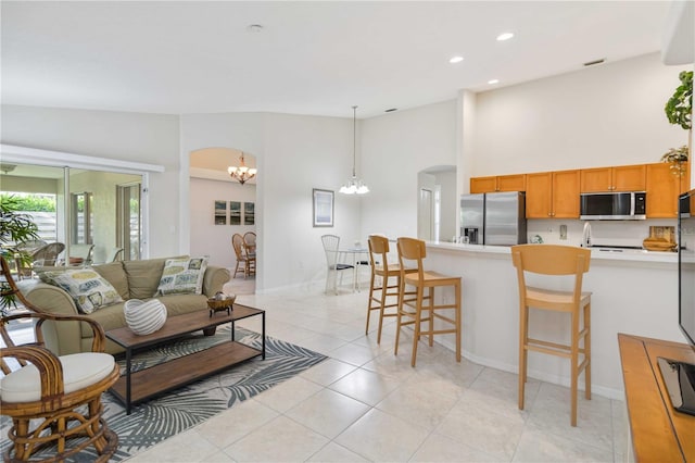 4845 Post Pointe Dr, Sarasota, FL 34233 - living room with a chandelier, arched walkways, recessed lighting, light tile patterned flooring, and high vaulted ceiling
