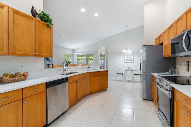 4845 Post Pointe Dr, Sarasota, FL 34233 - kitchen with appliances with stainless steel finishes, vaulted ceiling, light countertops, a chandelier, and brown cabinets