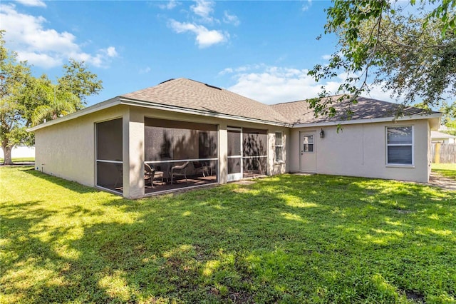 4845 Post Pointe Dr, Sarasota, FL 34233 - back of house with a lawn, stucco siding, a sunroom, and roof with shingles