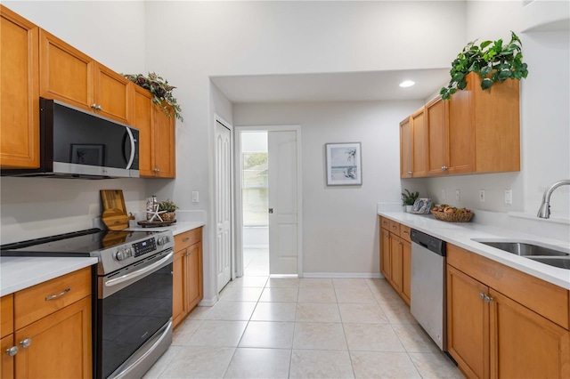 4845 Post Pointe Dr, Sarasota, FL 34233 - kitchen with appliances with stainless steel finishes, light countertops, light tile patterned flooring, brown cabinetry, and recessed lighting