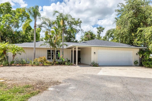 2866 E Rainbow Cir, Sarasota, FL 34231 - view of front of house with concrete driveway, a garage, and a shingled roof