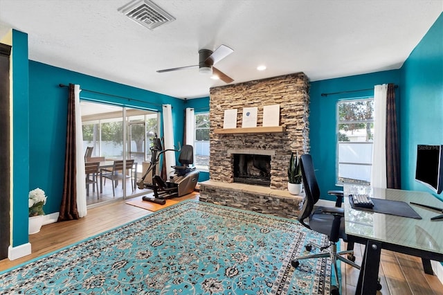 2866 E Rainbow Cir, Sarasota, FL 34231 - home office with a ceiling fan, wood finished floors, healthy amount of natural light, a fireplace, and a textured ceiling