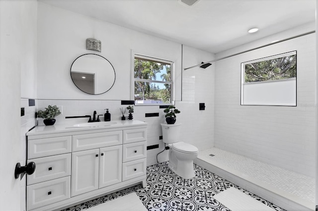 2866 E Rainbow Cir, Sarasota, FL 34231 - bathroom featuring tile walls, vanity, tiled shower, tile patterned floors, and wainscoting
