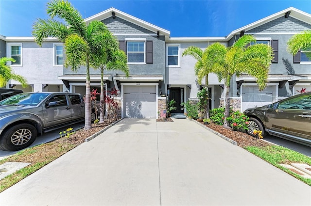 8676 Ice Wine St, Sarasota, FL 34238 - townhome / multi-family property featuring a garage, driveway, and stucco siding