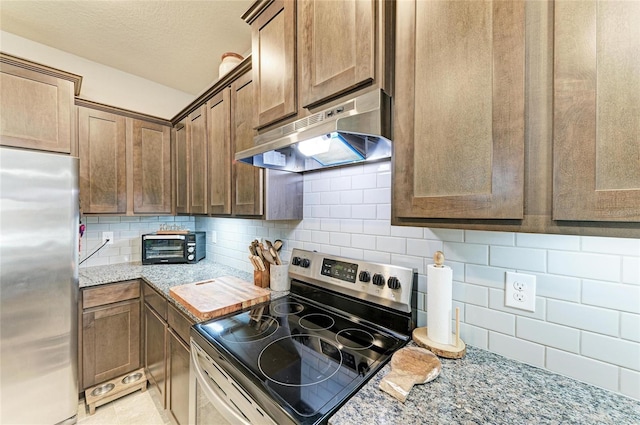 8676 Ice Wine St, Sarasota, FL 34238 - kitchen with stainless steel appliances, range hood, backsplash, light stone countertops, and a textured ceiling