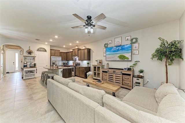 8676 Ice Wine St, Sarasota, FL 34238 - living area featuring arched walkways, ceiling fan, light tile patterned floors, and recessed lighting