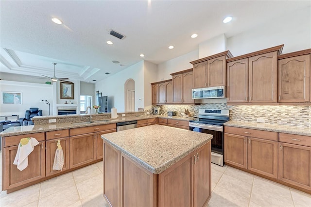 11915 Oak Ridge Dr, Parrish, FL 34219 - kitchen with stainless steel appliances, backsplash, a kitchen island, a ceiling fan, and open floor plan