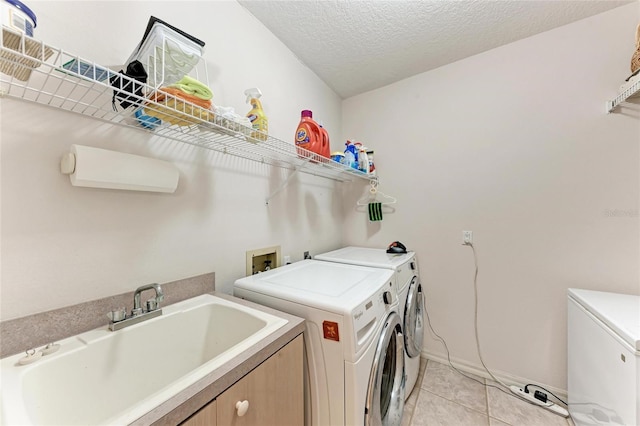 11915 Oak Ridge Dr, Parrish, FL 34219 - laundry room featuring separate washer and dryer, light tile patterned flooring, and a textured ceiling