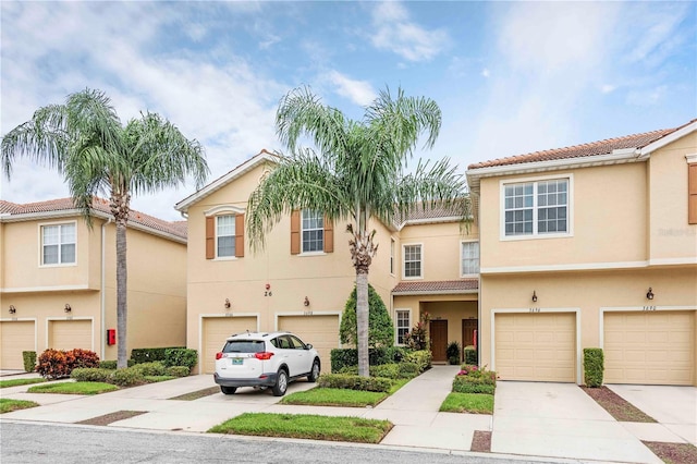 3698 Parkridge Cir Unit 26-104, Sarasota, FL 34243 - multi unit property with an attached garage, driveway, stucco siding, and a tile roof