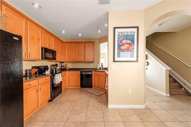 3698 Parkridge Cir Unit 26-104, Sarasota, FL 34243 - kitchen with black appliances, light tile patterned flooring, recessed lighting, dark countertops, and arched walkways