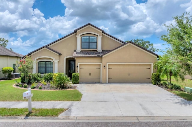 9123 Raes Creek Pl, Palmetto, FL 34221 - view of front of property with stucco siding, driveway, a front lawn, and a garage