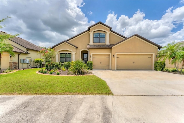 9123 Raes Creek Pl, Palmetto, FL 34221 - mediterranean / spanish house featuring stucco siding, concrete driveway, a front lawn, and a garage