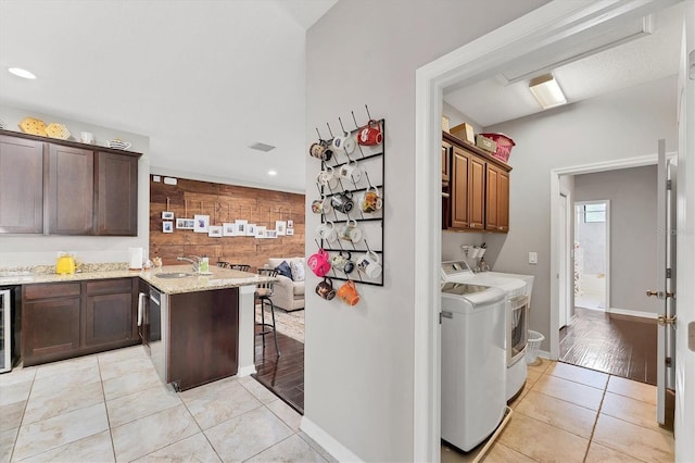 9123 Raes Creek Pl, Palmetto, FL 34221 - kitchen featuring washer and clothes dryer, light tile patterned flooring, a peninsula, light stone countertops, and wine cooler