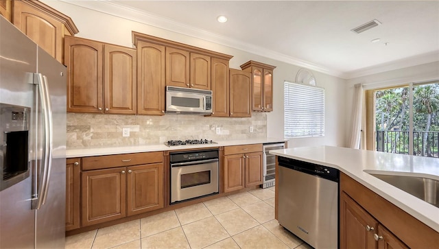 1512 3rd Street Cir E, Palmetto, FL 34221 - kitchen featuring stainless steel appliances, beverage cooler, ornamental molding, light countertops, and brown cabinetry
