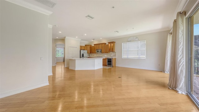 1512 3rd Street Cir E, Palmetto, FL 34221 - unfurnished living room featuring ornamental molding, light wood-type flooring, wine cooler, and recessed lighting