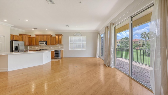1512 3rd Street Cir E, Palmetto, FL 34221 - kitchen featuring stainless steel appliances, wine cooler, light countertops, brown cabinetry, and backsplash