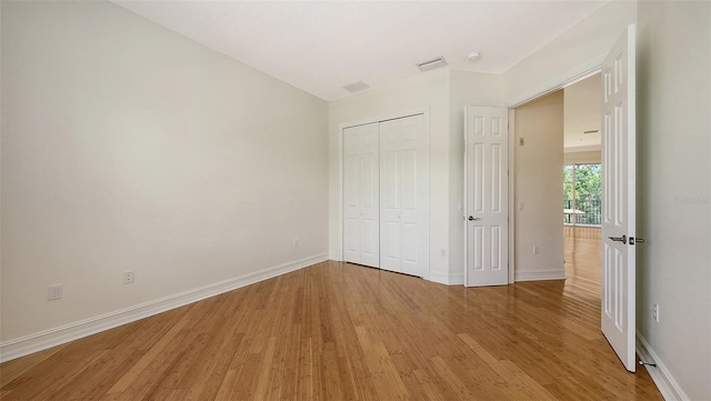 1512 3rd Street Cir E, Palmetto, FL 34221 - unfurnished bedroom featuring light wood-type flooring and a closet