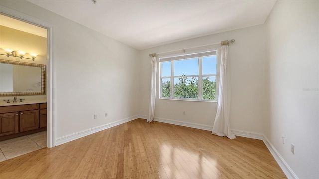 1512 3rd Street Cir E, Palmetto, FL 34221 - unfurnished bedroom featuring light wood-type flooring and ensuite bathroom