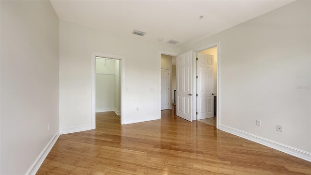 1512 3rd Street Cir E, Palmetto, FL 34221 - unfurnished bedroom with a spacious closet, light wood-type flooring, and a closet