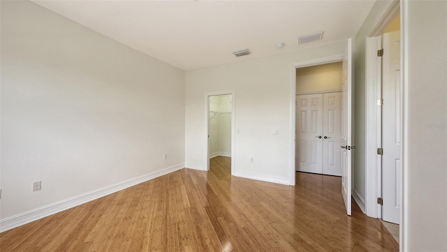 1512 3rd Street Cir E, Palmetto, FL 34221 - unfurnished bedroom with light wood-style floors, a walk in closet, and a closet
